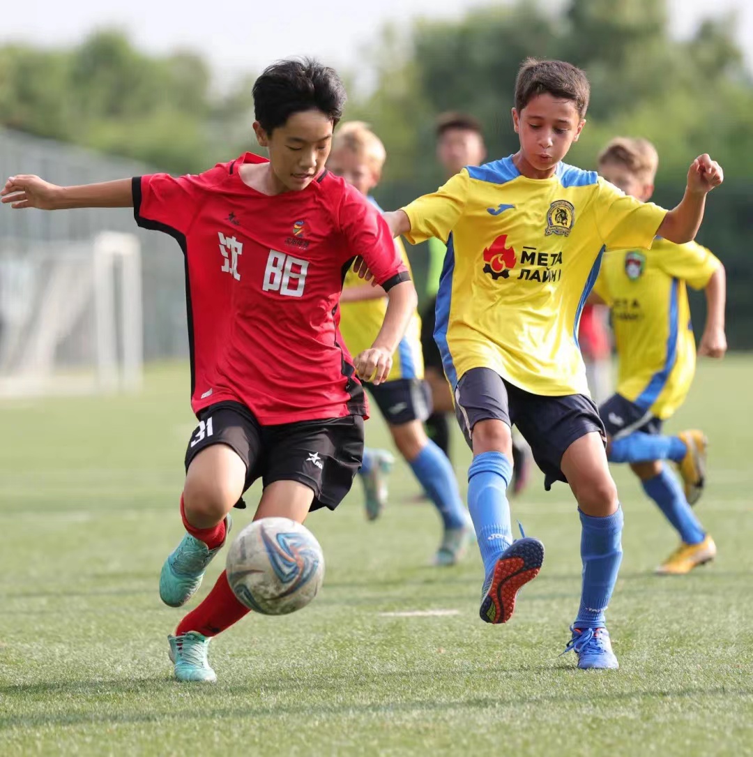 A young Chinese footballer (L) from Shenyang battles the ball with a Serbian player during the tournament in Shenyang, China. /Peace Cup