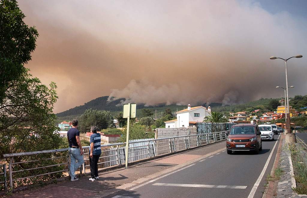 Two people at Nuestra Senora del Rosario, August 17, 2023, look at huge clouds of smoke from a wildfire which broke out almost two days ago and is raging in the northeastern part of the Canary island of Tenerife. /CFP