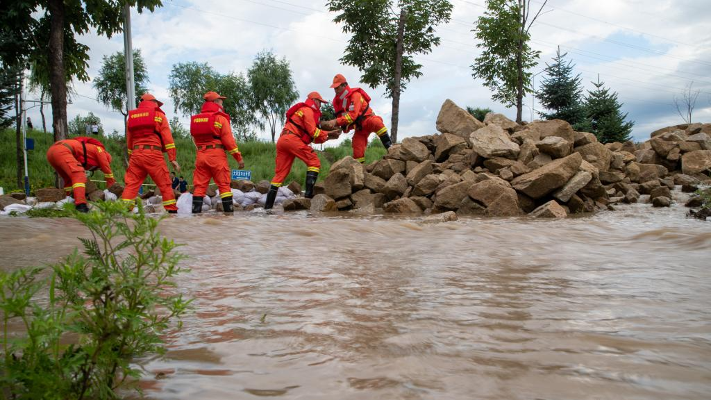 Firefighters transfer rocks to block floods near Dawan Village of Dong'an District, Mudanjiang, northeast China's Heilongjiang Province, August 5, 2023. /Xinhua