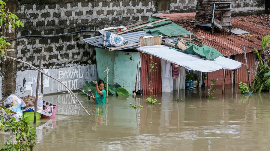 A resident wades through floodwater triggered by Typhoon Doksuri in Bulacan Province, the Philippines, July 31, 2023. /Xinhua