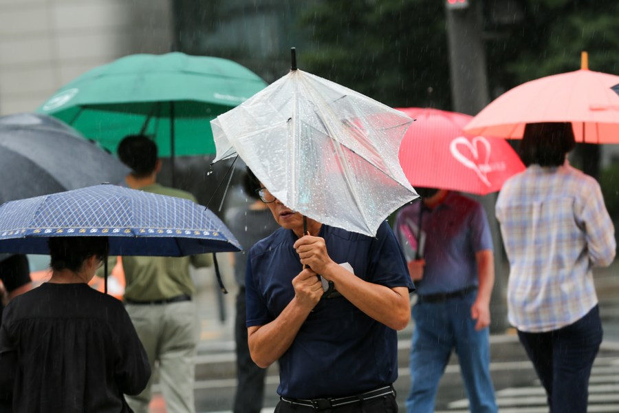 People walk on a street in the rain brought by Typhoon Khanun in Seoul, South Korea, August 10, 2023. /Xinhua