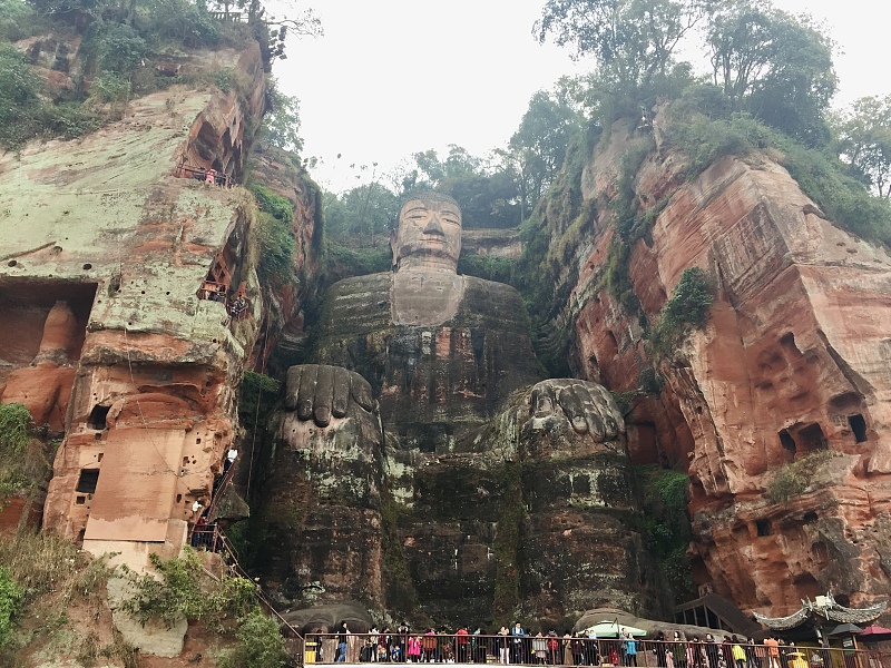 People visit the Giant Buddha at a scenic area in Leshan City, Sichuan Province. /CFP