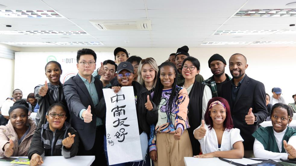 Sanele Ntuli (2nd R), a mandarin teacher at the Confucius Institute at Durban University of Technology, poses for a photo with faculty and students with a calligraphic work showing 