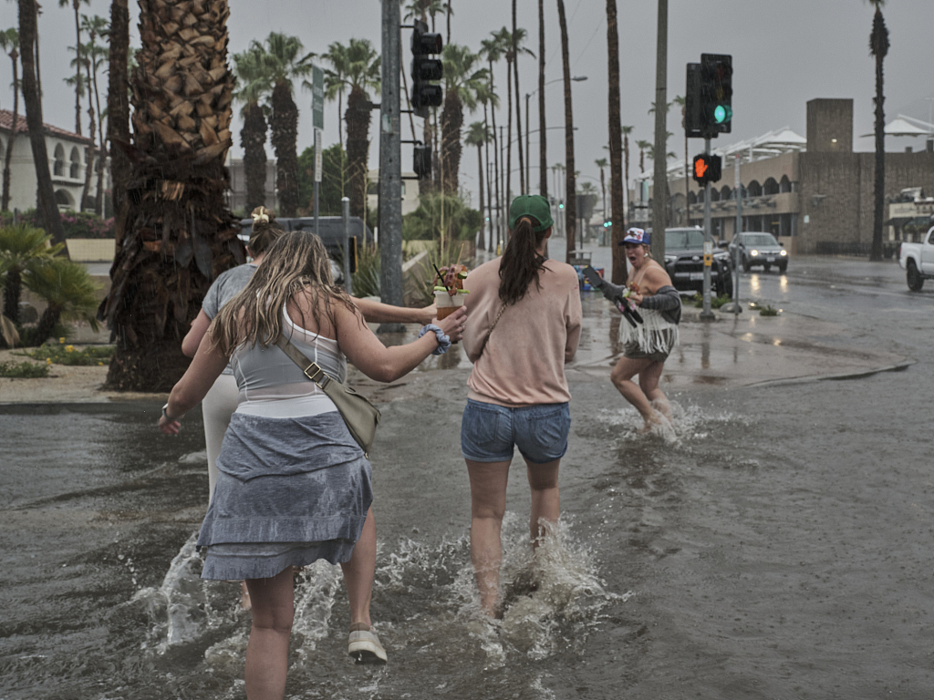 Tourists from Arkansas walk through the flooded streets of downtown Palm Springs, August 20, 2023, California. /CFP