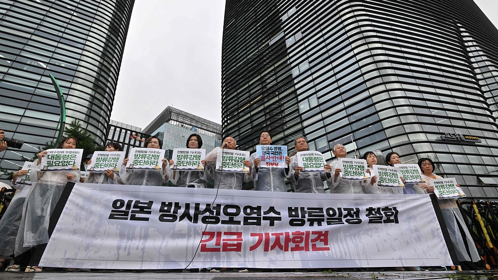 South Korean protesters hold a banner reading 