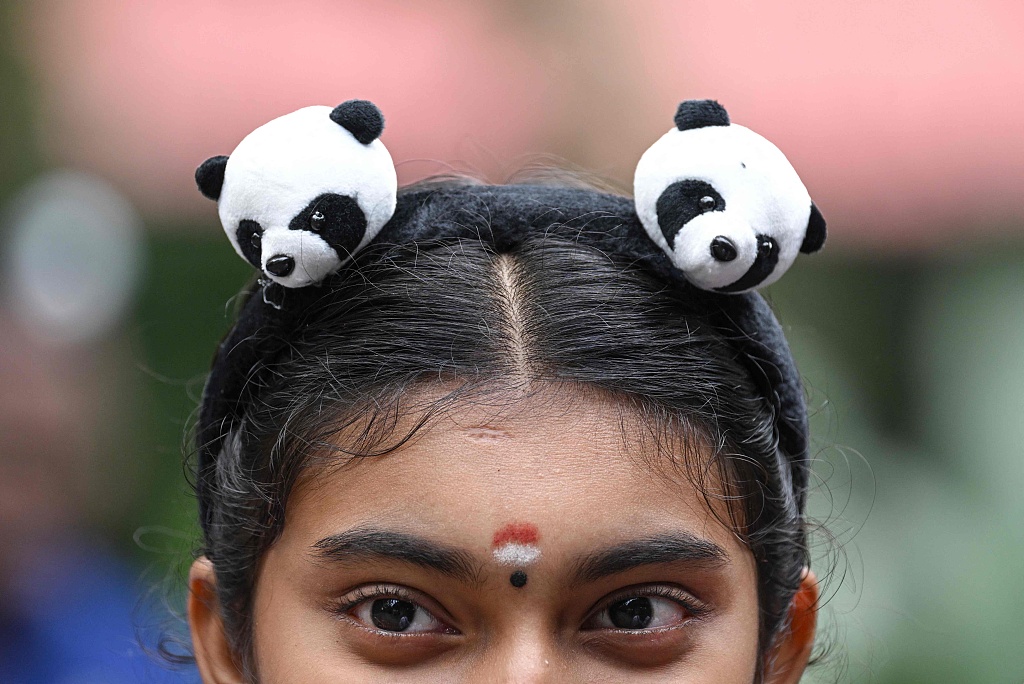 A girl wears a panda hairband at the 17th birthday celebrations for giant pandas Xing Xing and Liang Liang at Malaysia National Zoo in Kuala Lumpur on August 23, 2023. /CFP