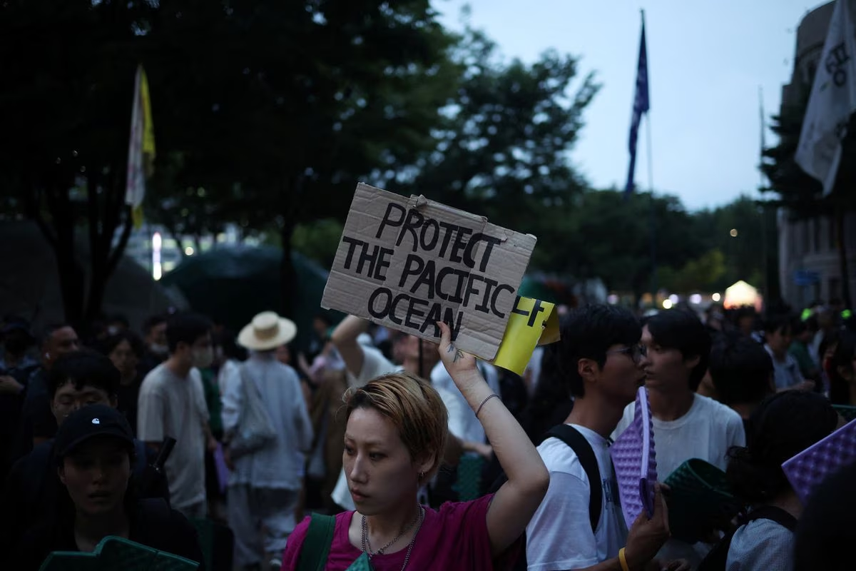 A woman holds up a placard in central Seoul, August 22, 2023. /Reuters
