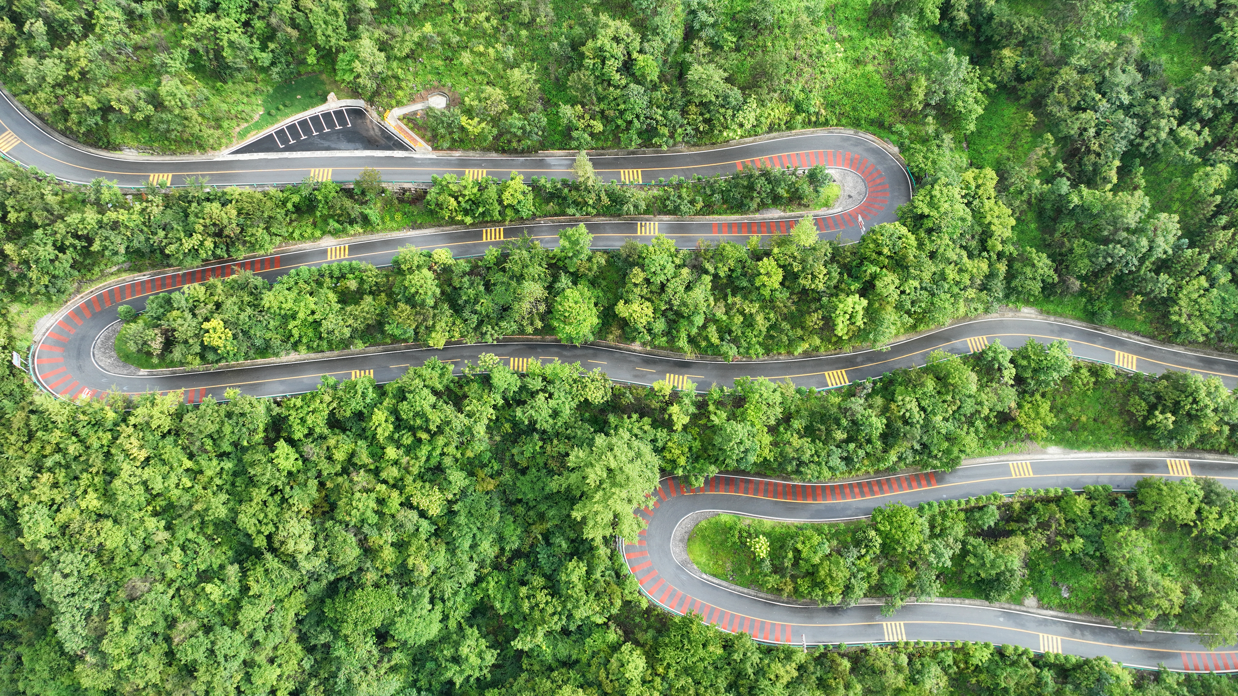 Photo taken on August 23, 2023 shows a road winding through a lush mountain in Fangxian, Hubei Province. /IC