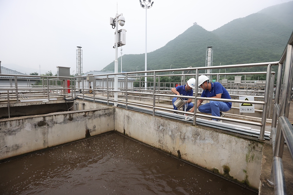 Two engineers take samples from the sewage pool for further testing in a sewage treatment plant, Mentougou District, Beijing, August 11, 2023. /CFP