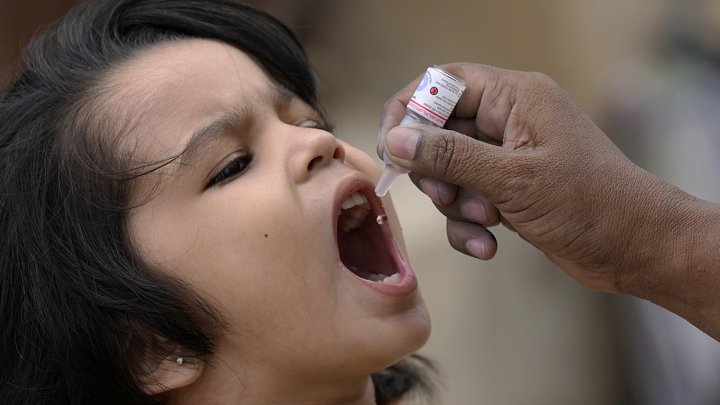 A health worker administers a polio vaccine to a child at a neighborhood in Karachi, Pakistan, June 19, 2023. /CFP