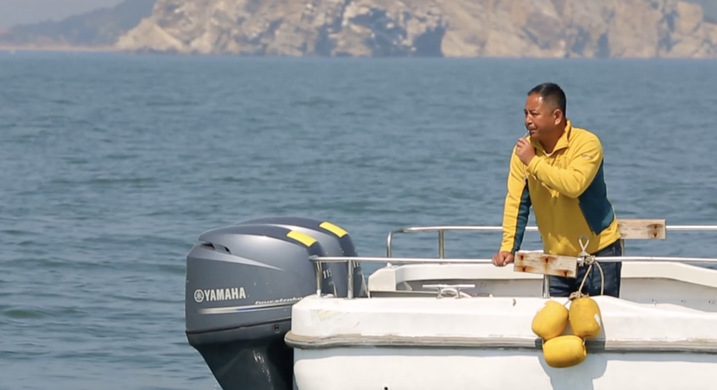 Liang Zeye, a guardian of the East Asian finless porpoises, whistles to attract his finless porpoise friends in northeast China's Liaoning Province. /CMG