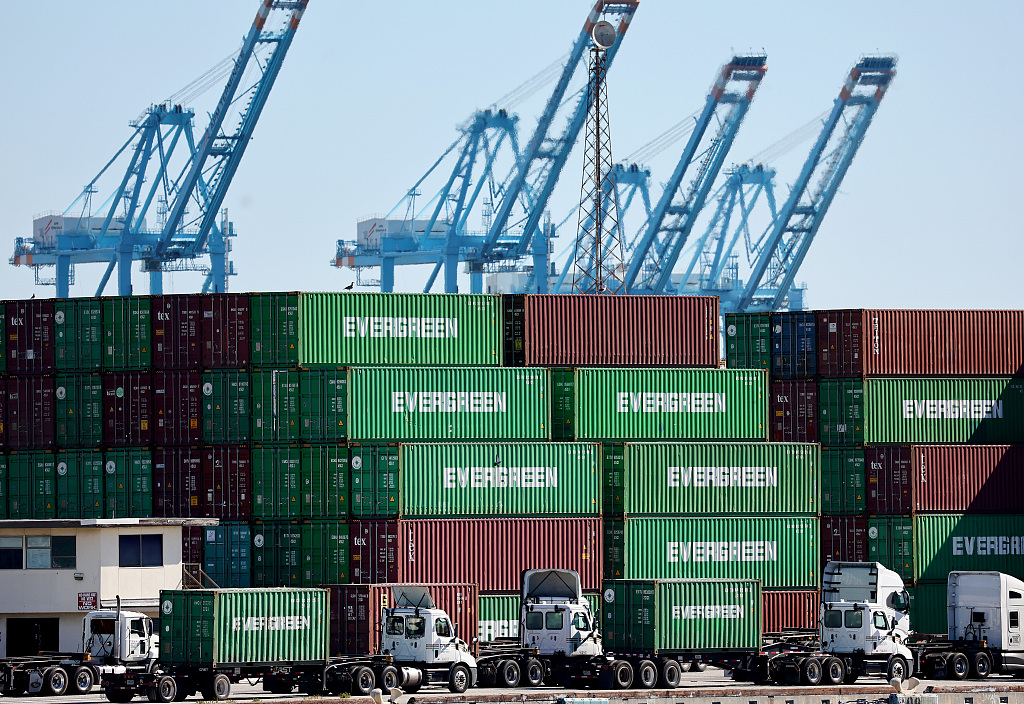 Trucks drive near shipping containers stacked at the Port of Los Angeles, California, the U.S., February 7, 2023. /CFP