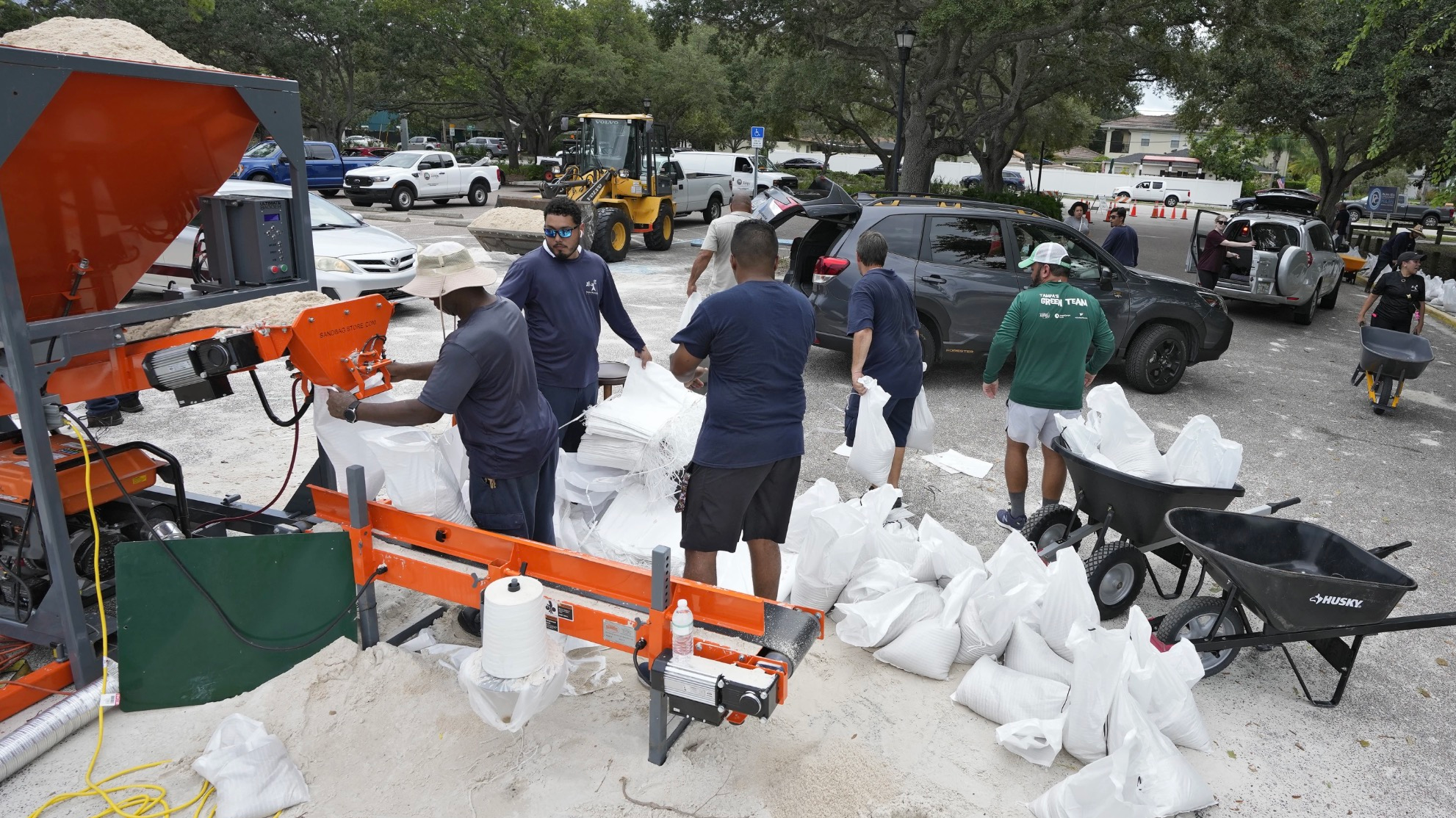 Members of the Tampa Parks and Recreation Department help residents with sandbags, August 28, 2023. /AP