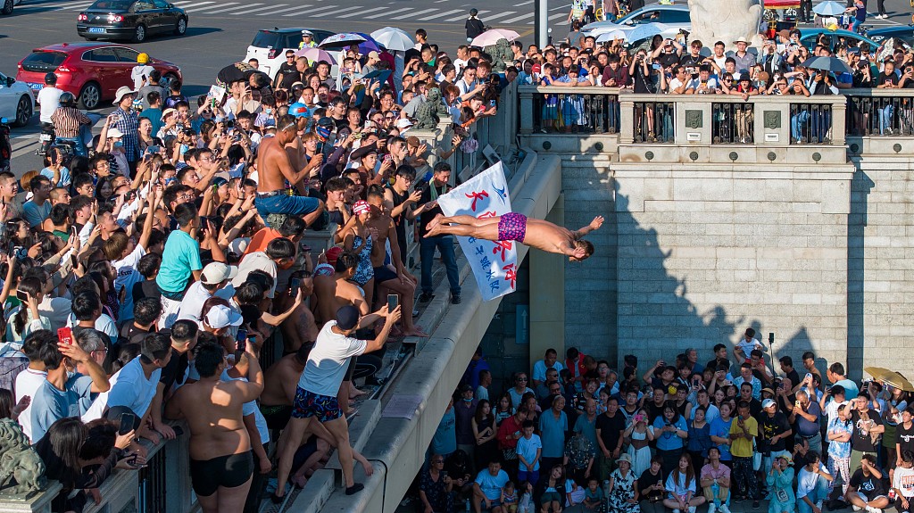 A photo taken on August 28, 2023, shows a man diving into the Haihe River in front of crowds of onlookers in Tianjin, China. /CFP