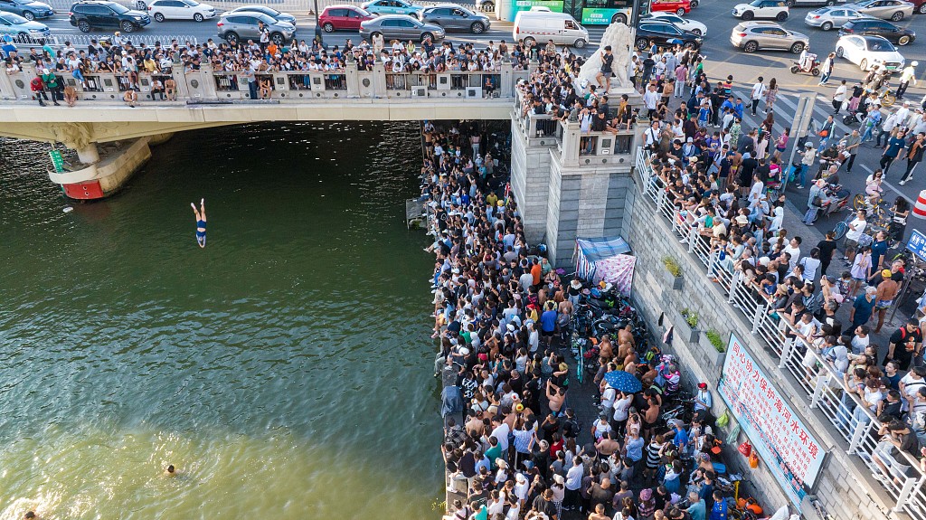 A photo taken on August 28, 2023, shows a man diving into the Haihe River in front of crowds of onlookers in Tianjin, China. /CFP