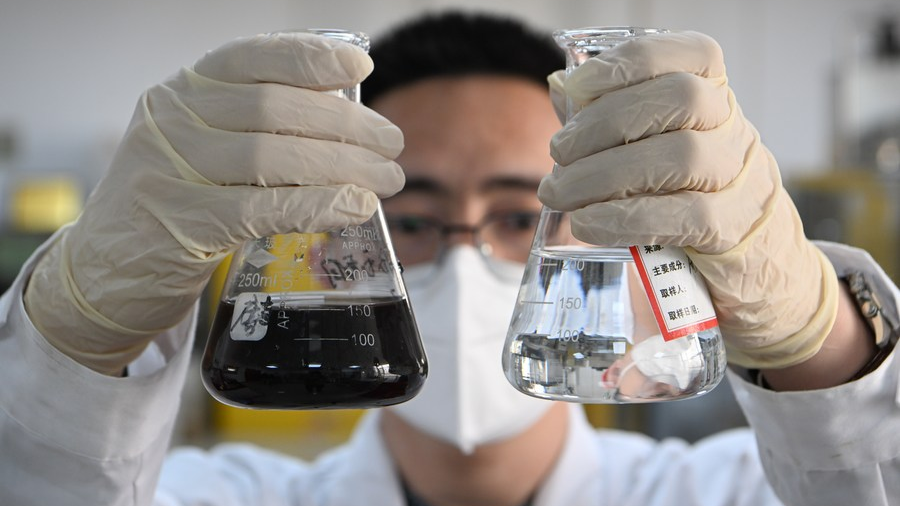 A researcher displays industrial wastewater and processed recycled water at the National Research Center of Industrial Water Treatment Engineering and Technology in north China's Tianjin Municipality, March 22, 2023. /Xinhua