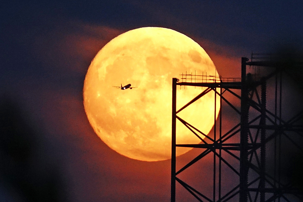 A plane flies across the blue supermoon in Dalian, Liaoning Province on Wednesday, August 30, 2023. /CFP