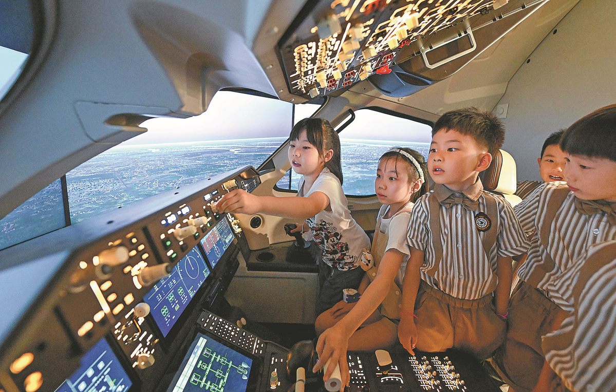 Children learn to pilot a plane on a C919 flight simulator at a children's science and technology museum in Tianjin, June 1, 2023. /Xinhua