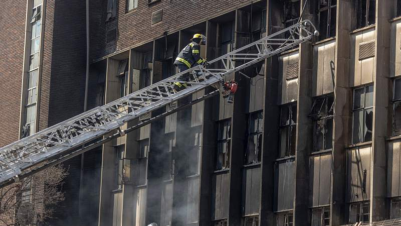 A firefighter climbs a ladder to extinguish a fire at an apartment block in Johannesburg, South Africa, August 31, 2023. /CFP