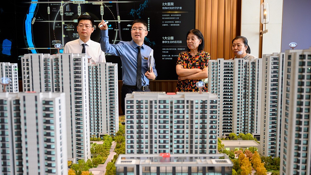 A salesperson introduces commercial housing to clients in north China's Shanxi Province, June 21, 2023. /CFP