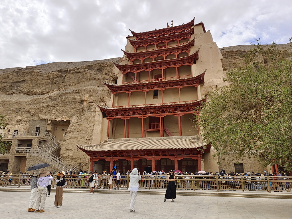 Photo taken on July 25, 2023 shows tourists visiting the Mogao Caves in Gansu Province. /CFP