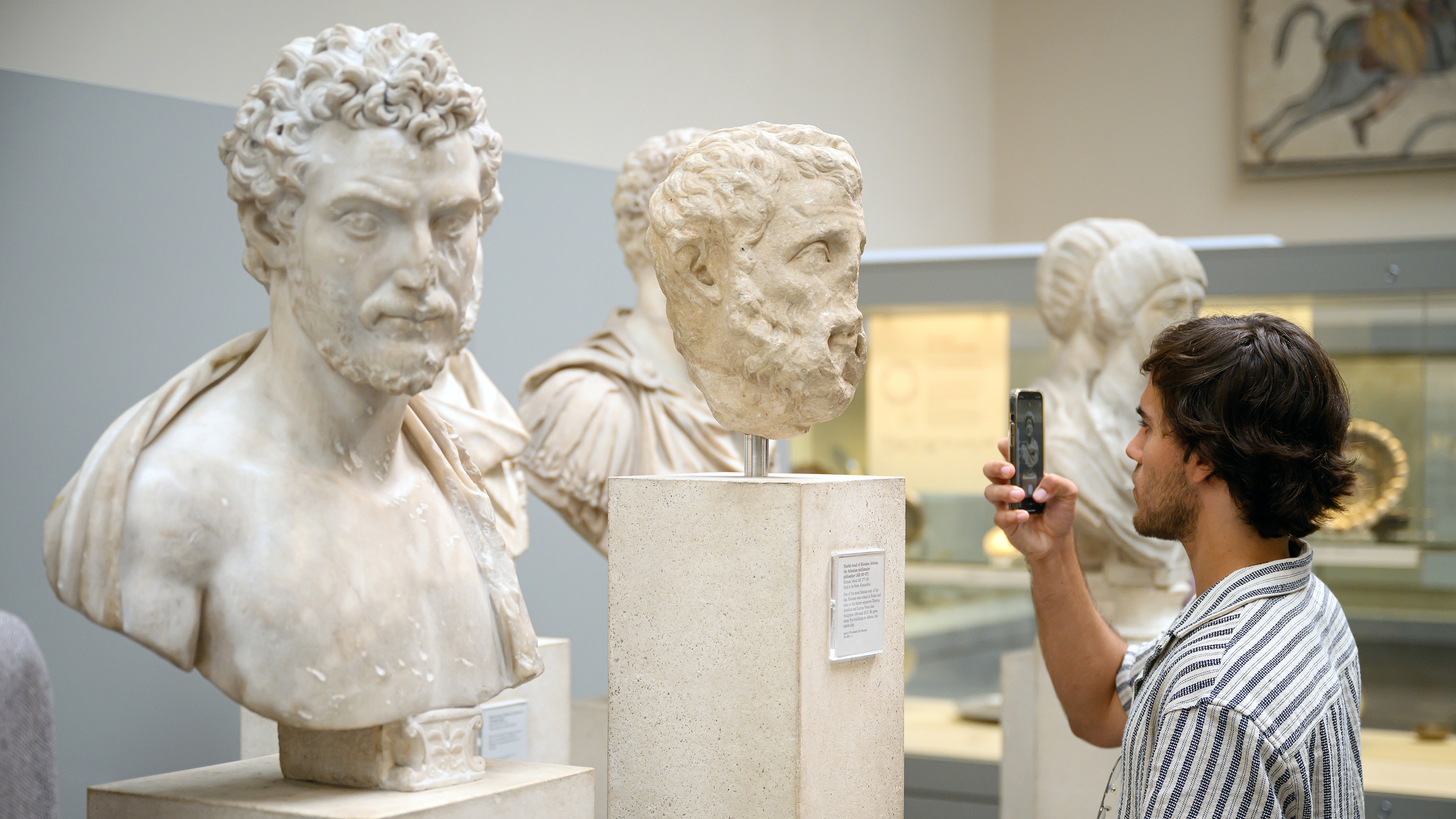 A visitor to the British Museum takes a photograph of a selection of Greek marble busts in London, UK, August 23, 2023. /CFP