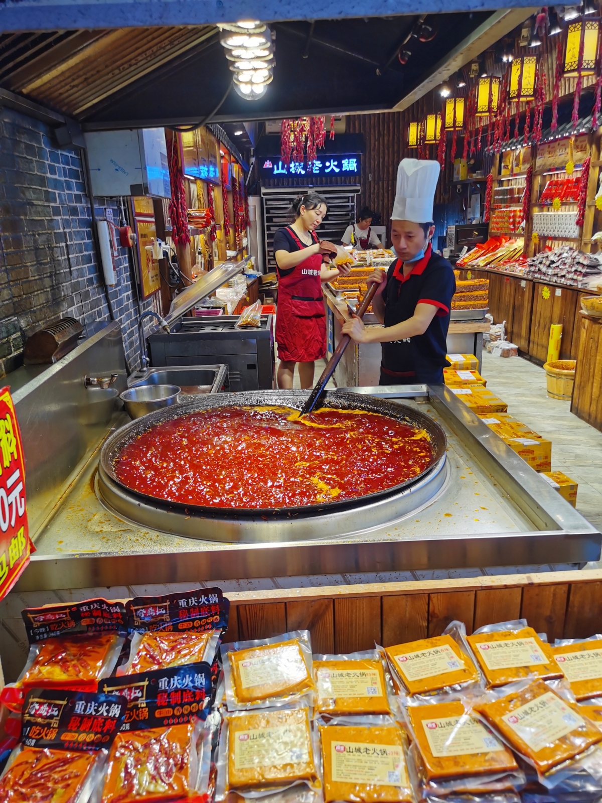 A chef makes a spicy hot pot soup base at Ciqikou ancient town in southwest China's Chongqing on August 21, 2023. /CGTN