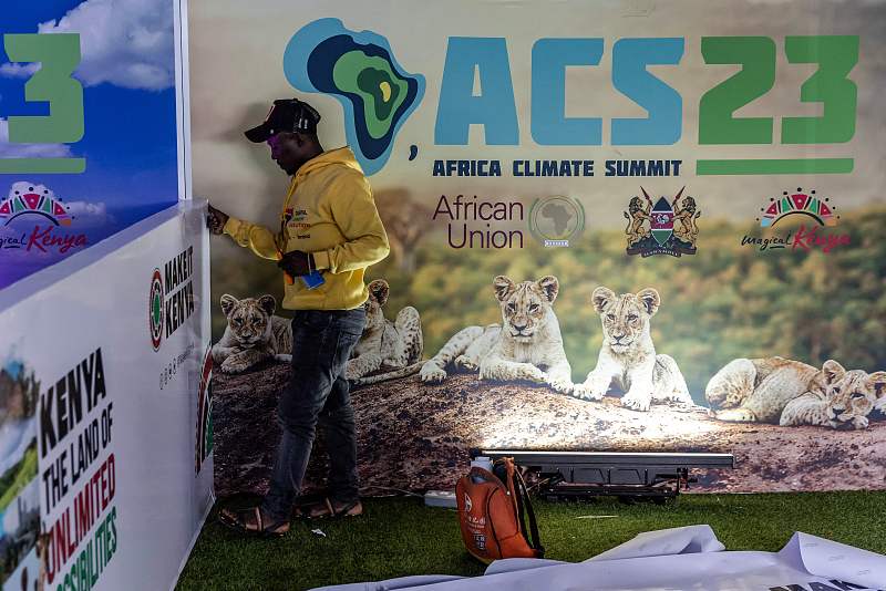 A worker installs some promotional stickers as he prepares the venue ahead of the Africa Climate Summit 2023 at the Kenyatta International Convention Center in Nairobi, Kenya, September 2, 2023./CFP