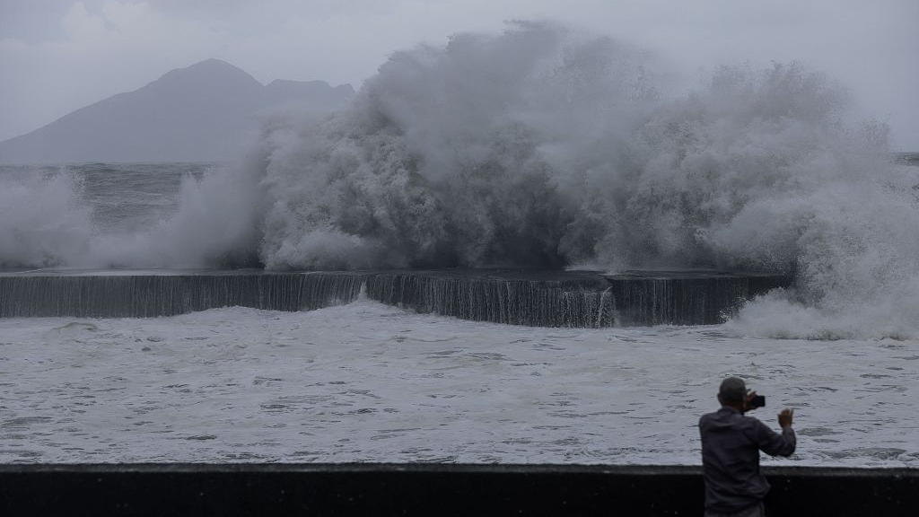 A man takes pictures of huge waves in Yilan as Typhoon Haikui makes landfall in eastern Taiwan region, September 3, 2023. /CFP