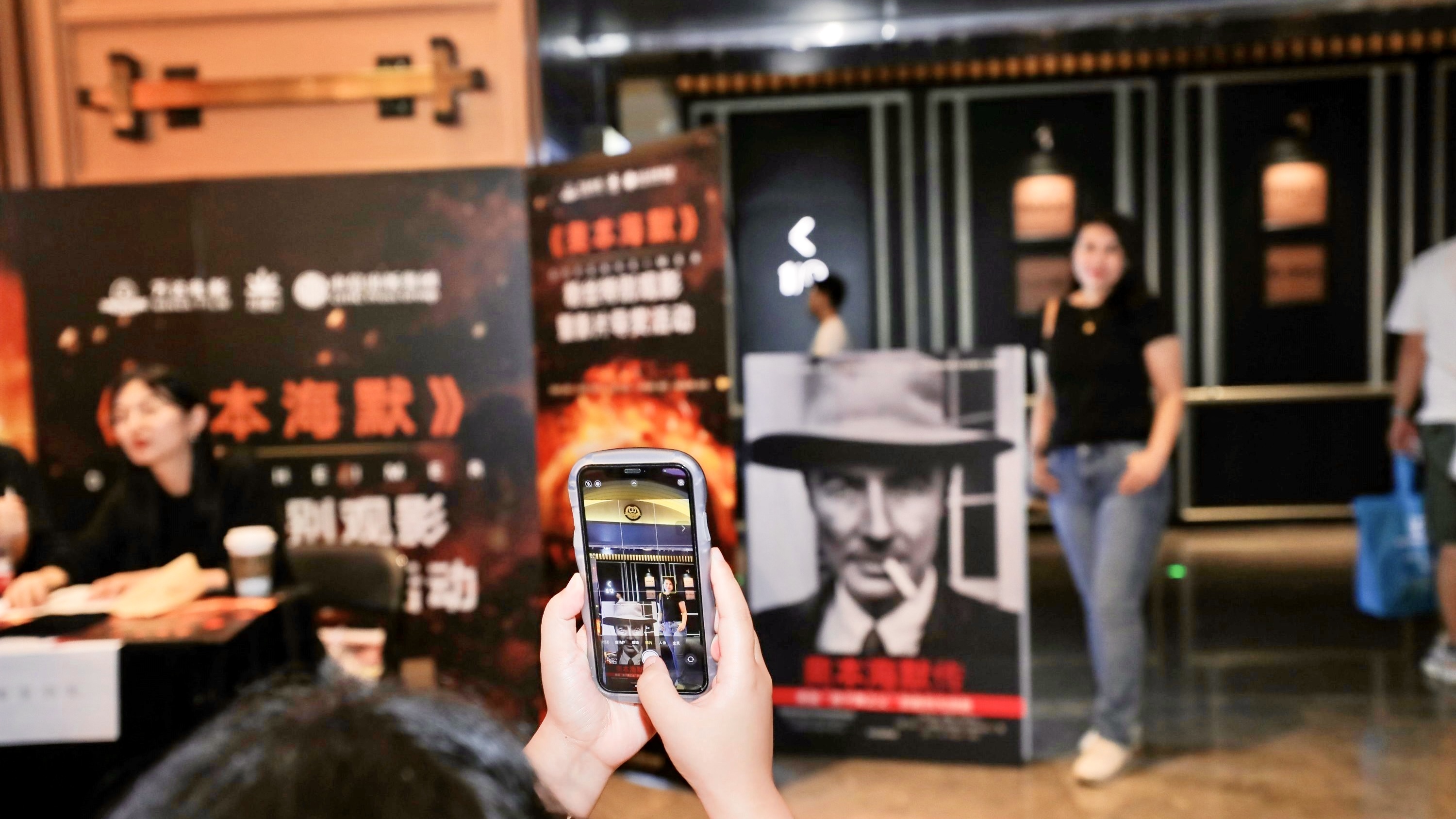 Fans are taking photos with posters at a screening of 'Oppenheimer' in Beijing on August 31, 2023. /Wanda Film