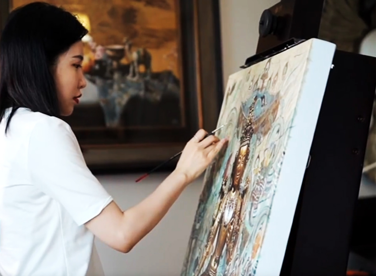 Young Chinese painter Mi Qiaoming works on an oil painting. /CGTN