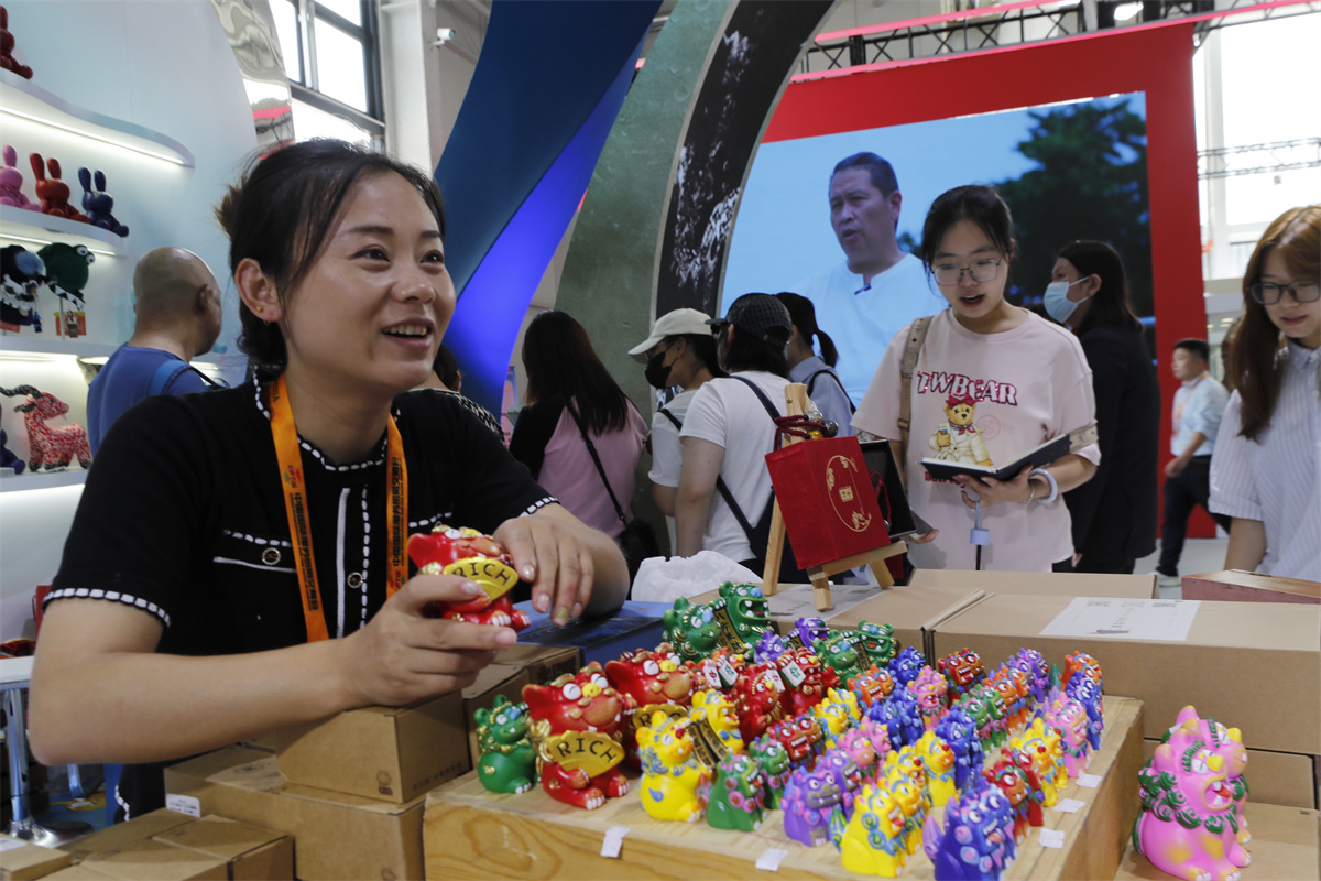 A woman shows colorful decorations in the shape of adorable lions carved on the railings of the Lugou Bridge in Beijing at an exhibition stand during the China International Fair for Trade in Services, September 4, 2023. /IC