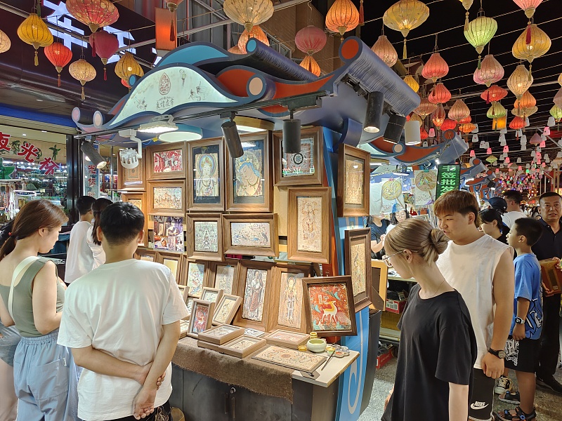 A file photo taken in July shows visitors exploring a night market in Dunhuang, northwest China's Gansu Province. /CFP