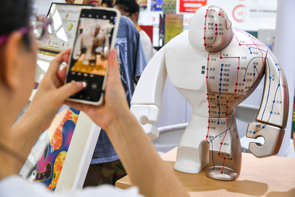 A visitor takes a photo of a model featuring acupuncture points in the human body at the China International Fair for Trade in Services in Beijing on Tuesday, September 5, 2023. /CFP