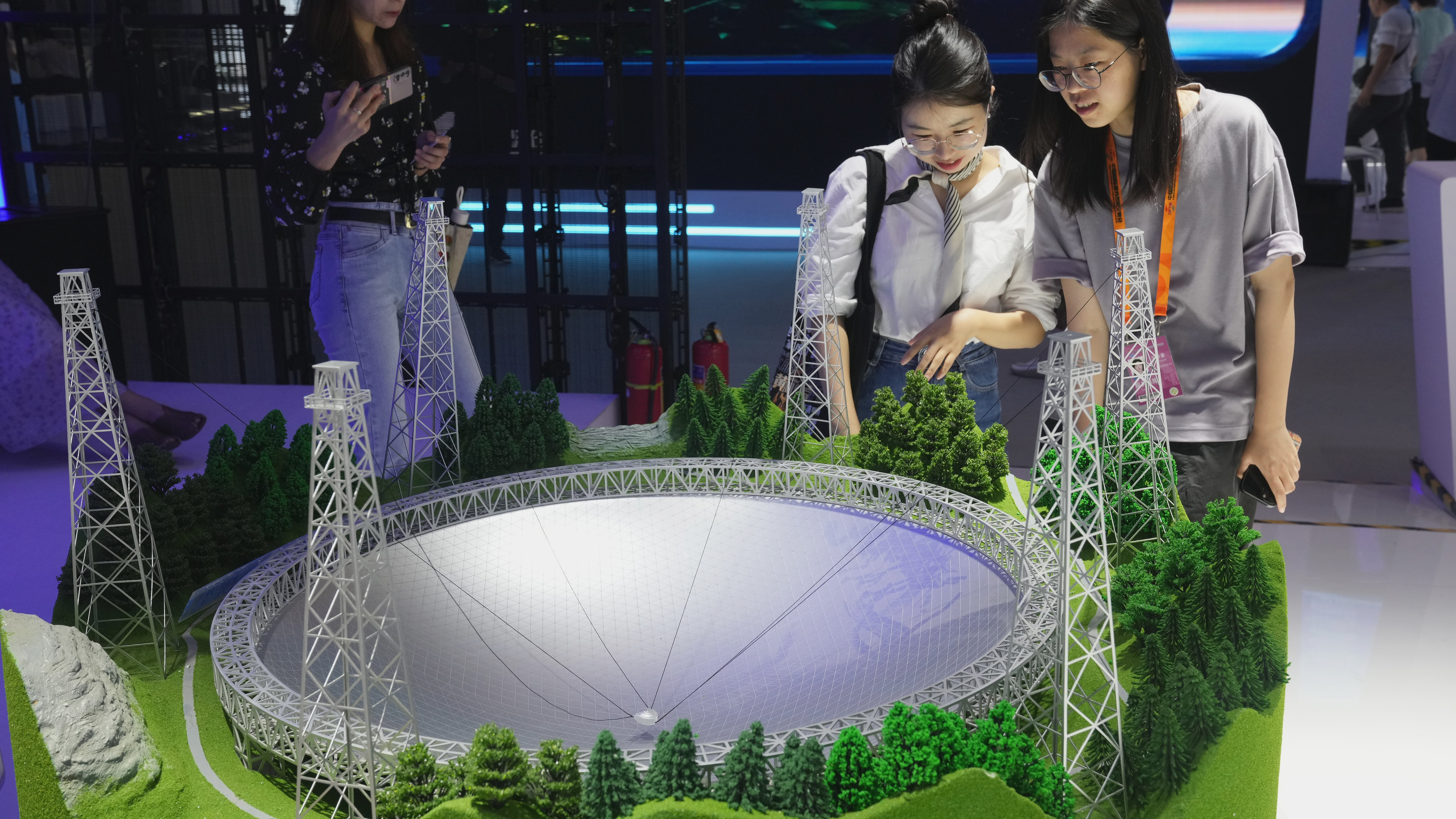 Visitors watch the model of the China's Eye of Heaven.