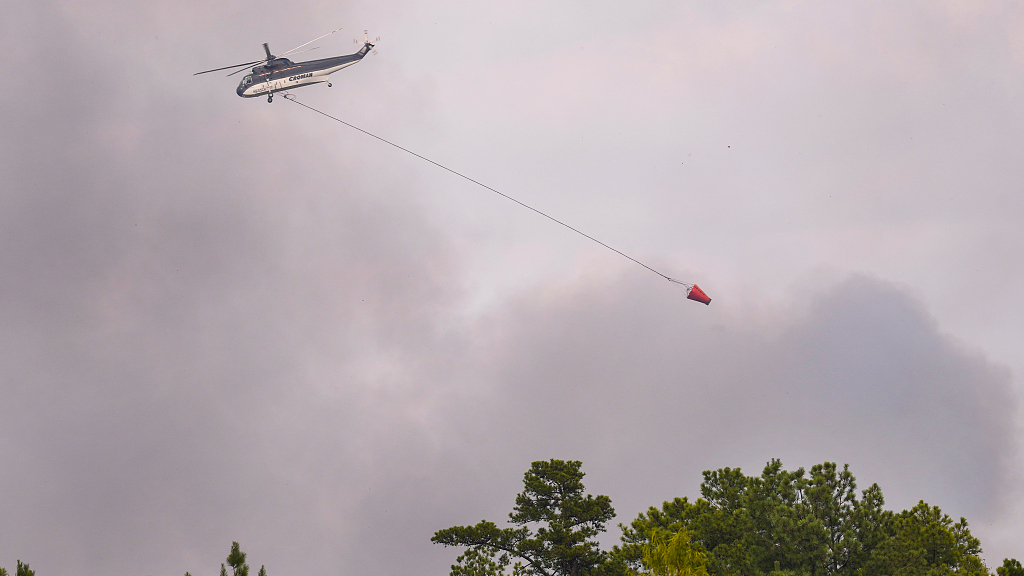 A firefighting helicopter flies over a wildfire in rural Walker County, Texas, the U.S., September 2, 2023. /CFP