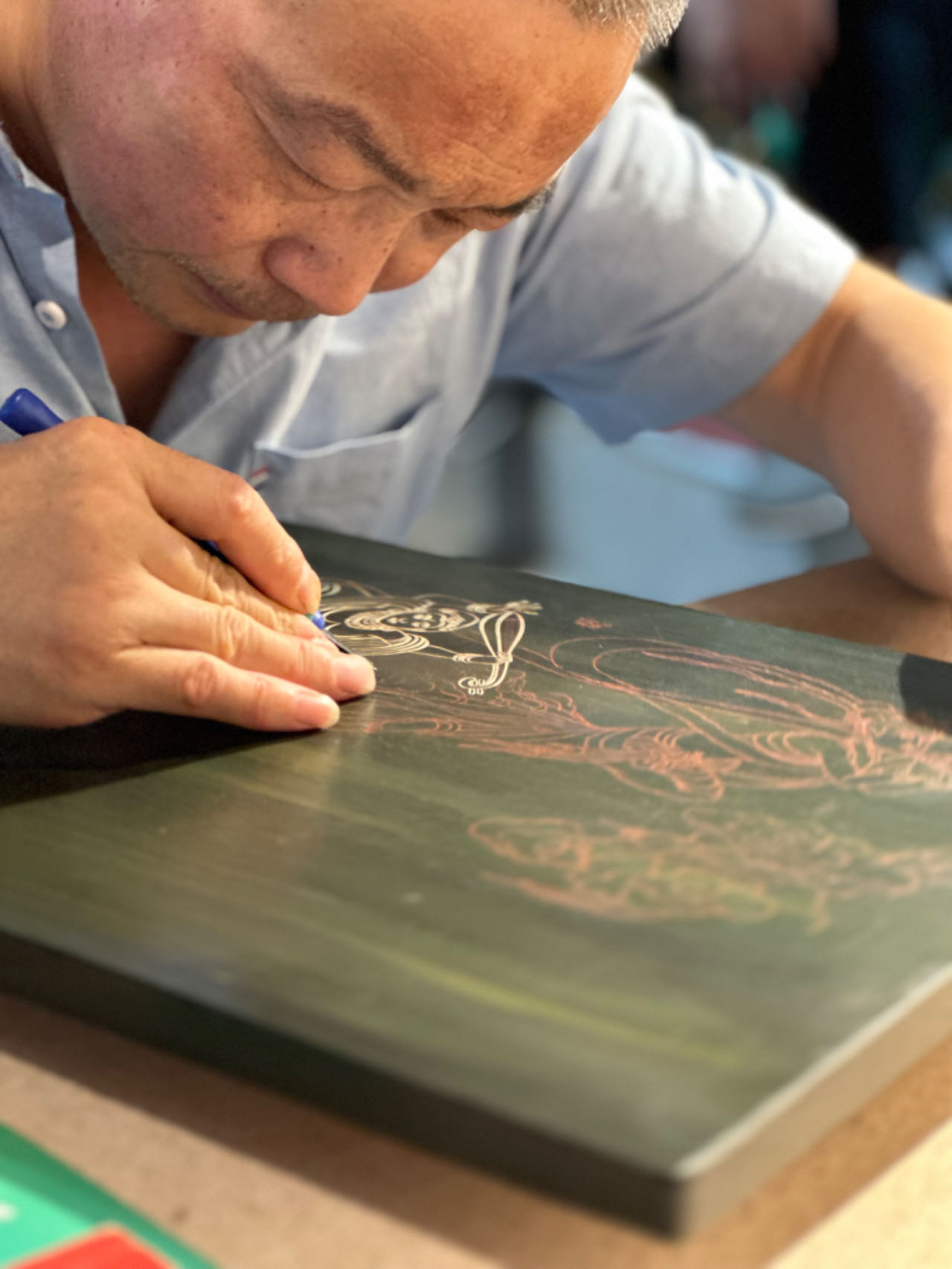 A craftsman works on an engraving at the Dunhuang Night Market in Dunhuang, Gansu Province on September 4, 2023. /CGTN