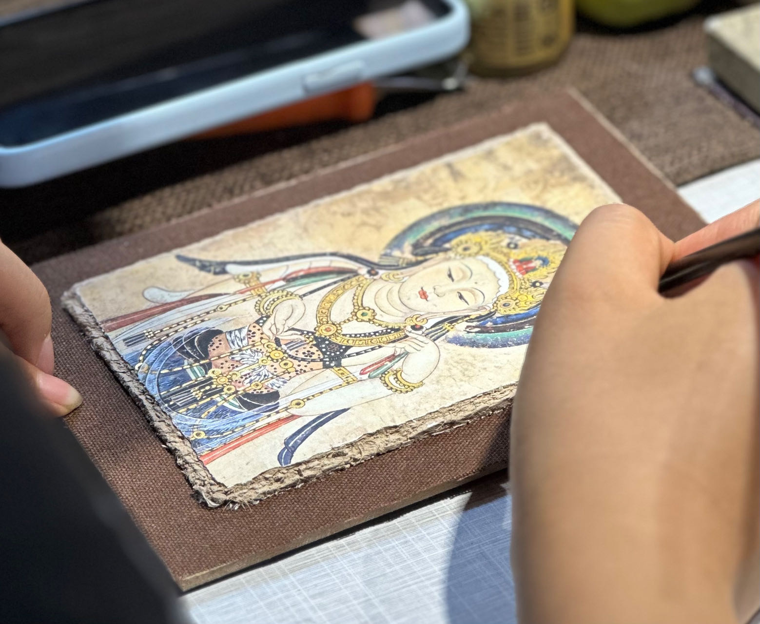 An artisan works on a painting at the Dunhuang Night Market in Dunhuang, Gansu Province on September 4, 2023. /CGTN