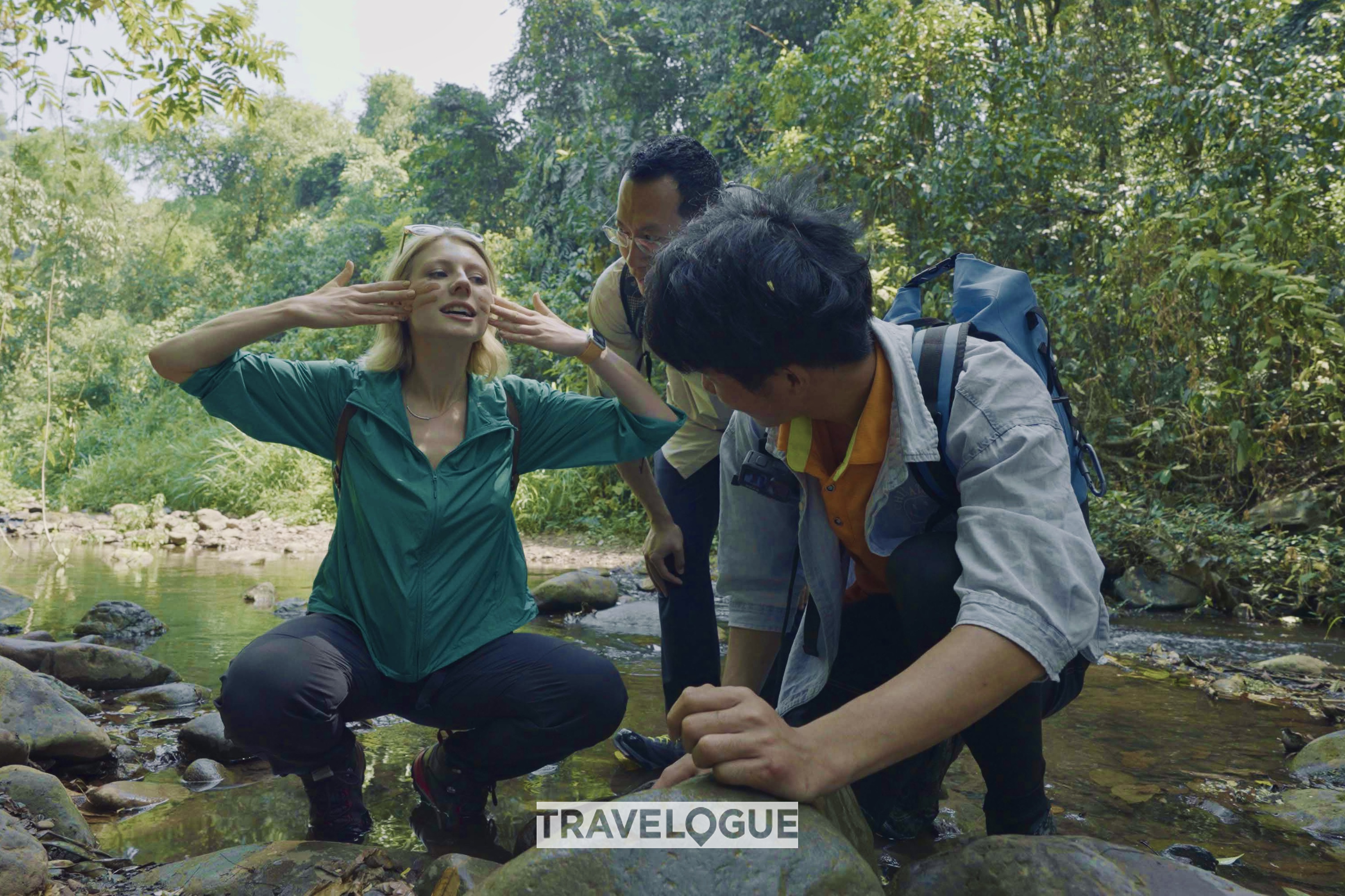 CGTN reporters try to use rocks to protect their skin in the rainforests of Xishuangbanna, Yunnan Province. /CGTN