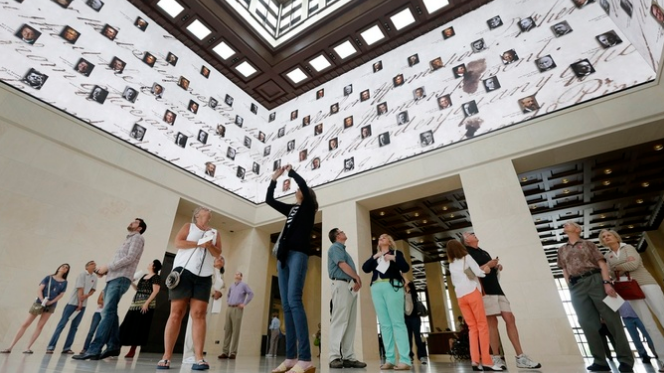 Visitors to the George W. Bush Presidential Library and Museum look upwards at a 360 degree video screen showing a video welcoming them to the center in Dallas, U.S., May 1, 2013. /AP