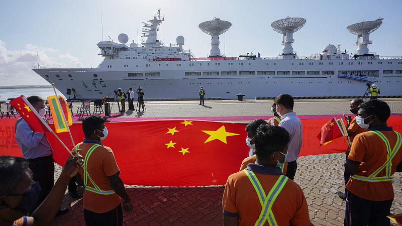 Sri Lankan port workers hold a Chinese national flag to welcome Chinese research ship Yuan Wang 5 as it arrives in Hambantota International Port in Hambantota, Sri Lanka, August 16, 2022. /CFP