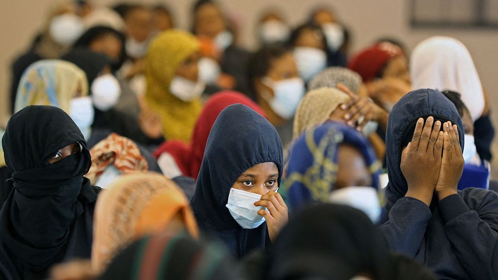 Nigerian migrants who voluntarily chose to return to their home country, cover their faces before flying out of Libya during an operation organised by the International Organisation for Migration (IOM) in Tripoli, August 21, 2023. /CFP