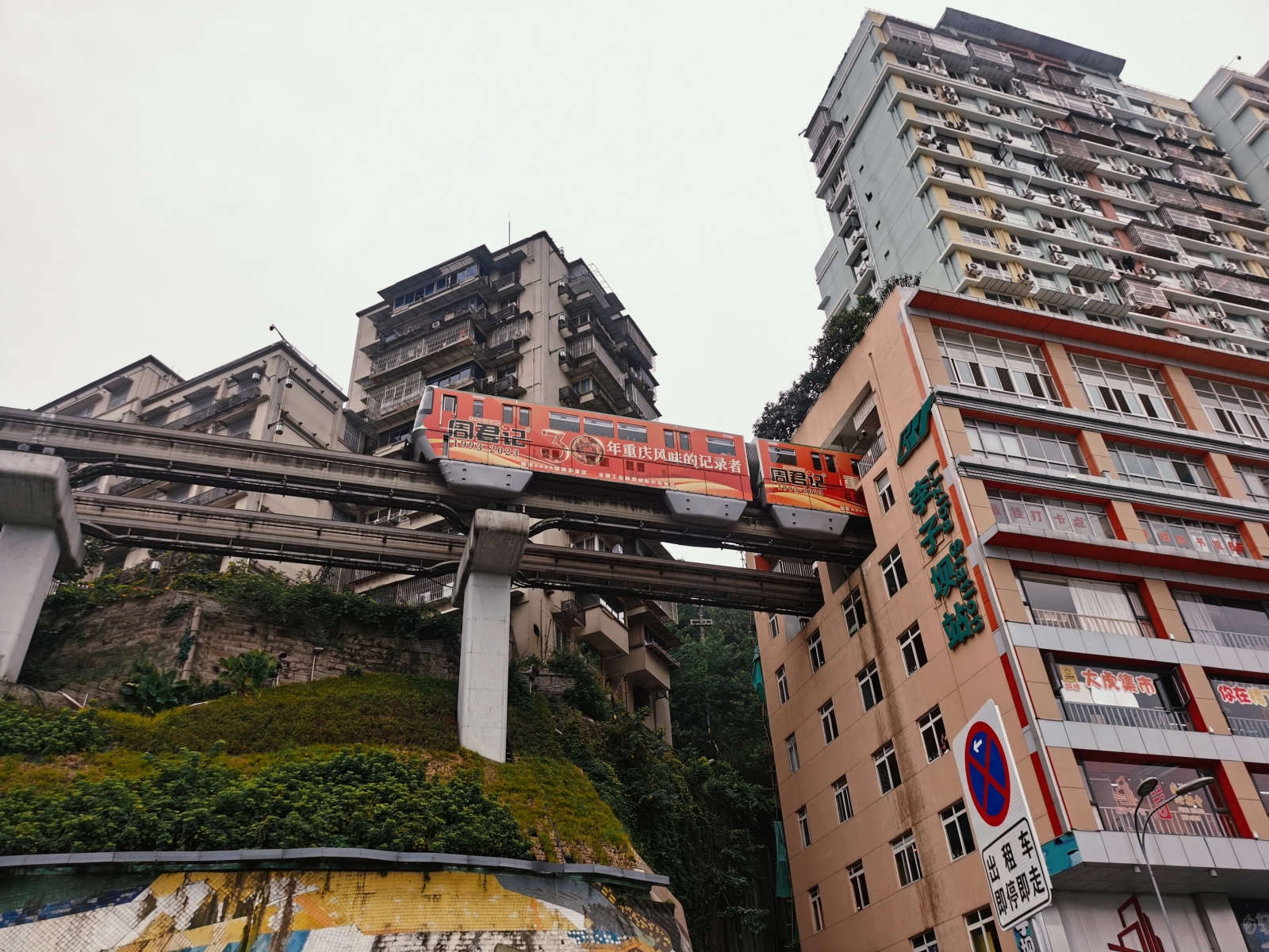 A monorail passenger train goes through a residential building in southwest China's Chongqing, on August 24, 2023. /CGTN
