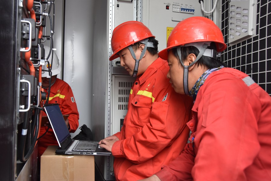 Workers at PetroChina's Tarim Oilfield branch set up photovoltaic equipment along the Tarim Desert Road in northwest China's Xinjiang Uygur Autonomous Region, March 20, 2022. /Xinhua