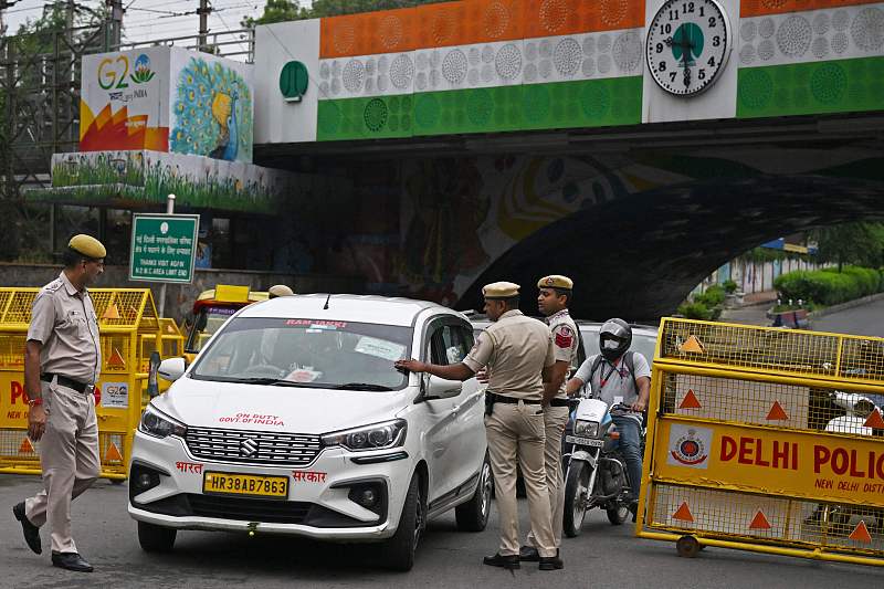 Police personnel check vehicles of commuters along a deserted road during the first session of the G20 Leaders' Summit in New Delhi, September 9, 2023. /CFP