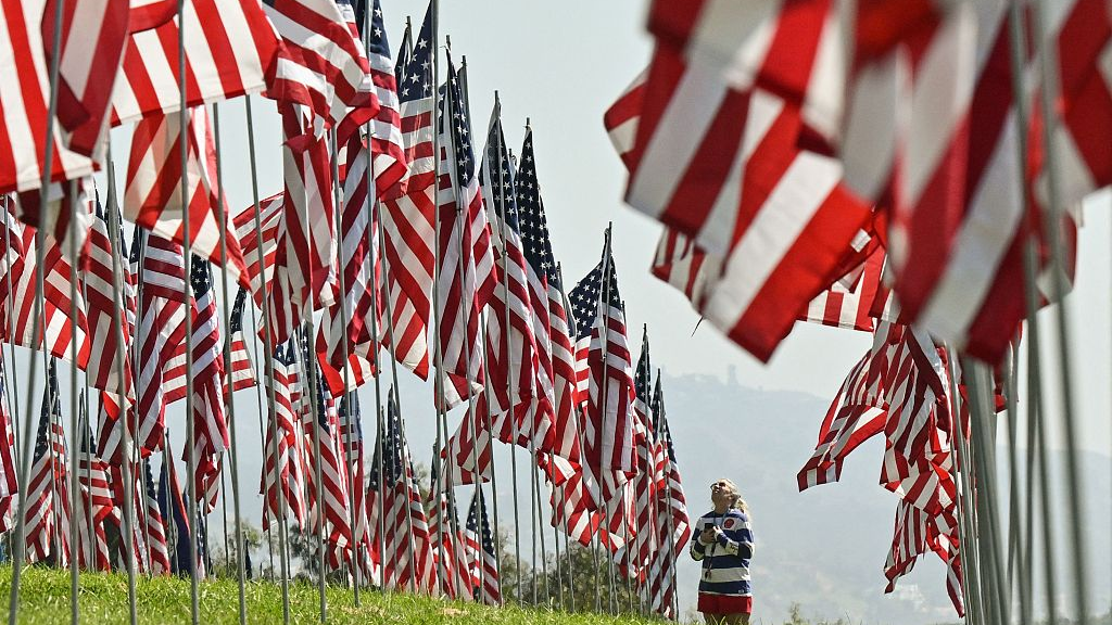 A visitor looks up at some of the nearly 3,000 flags representing the victims of the 9/11 terrorist attacks on the campus of Pepperdine University in Malibu, California, United States, September 8, 2023. /CFP