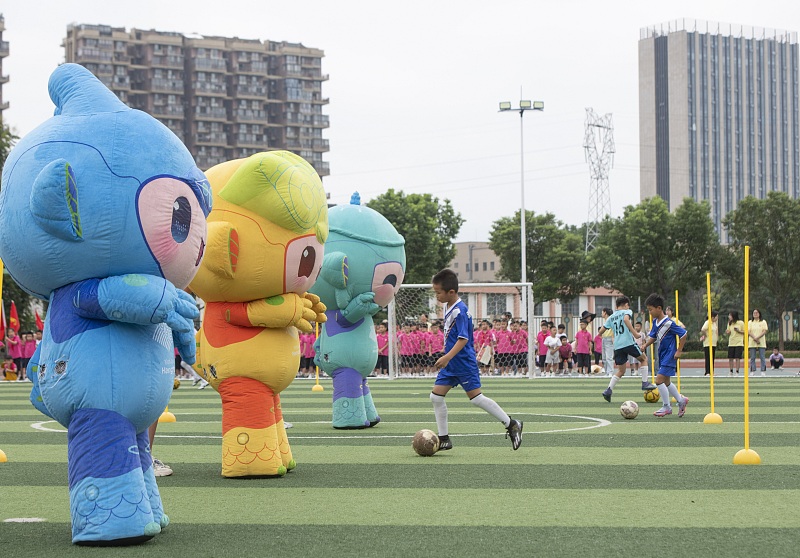 The three mascots of the 19th Asian Games appear in a football game in Jinhua City, Zhejiang Province. /CFP