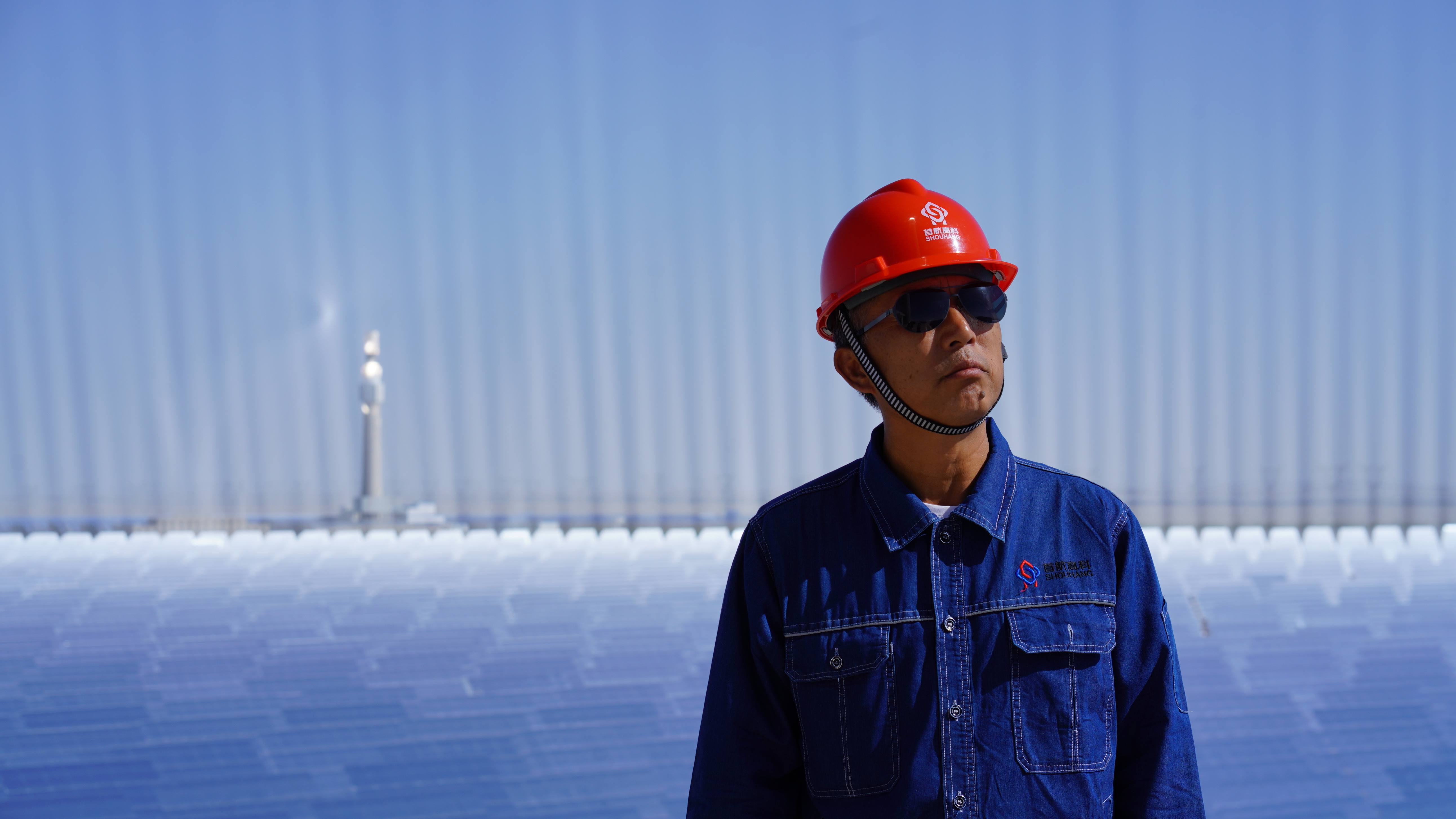 With arrays of heliostats as background, Liu Fuguo stands at the top of a 10-story building in a solar thermal power station, Dunhuang, northwest China's Gansu Province, September 9, 2023. Liang Si/CGTN