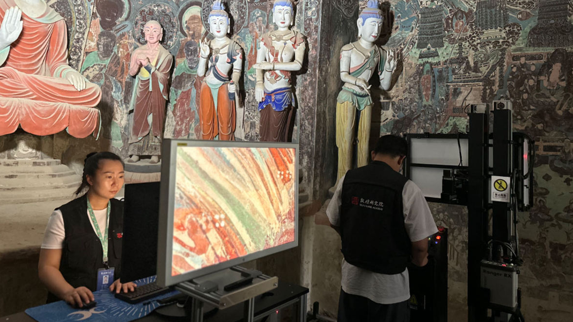 Staff from the Dunhuang Academy work on digitizing images taken in a cave at the Mogao Grottoes in Dunhuang City, northwest China's Gansu Province, September 5, 2023. /CGTN