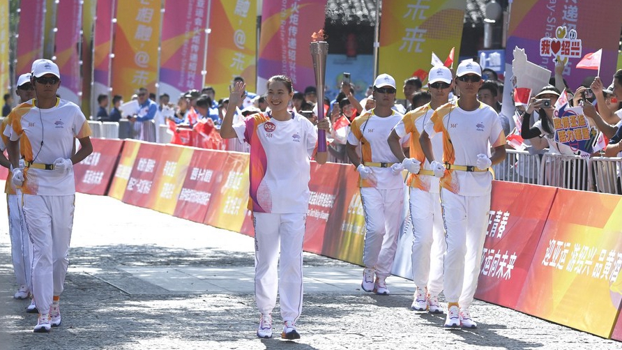 Torch bearer Lu Minjia runs the torch relay of the 19th Asian Games in Shaoxing, China's Zhejiang Province, September 11, 2023. /CFP